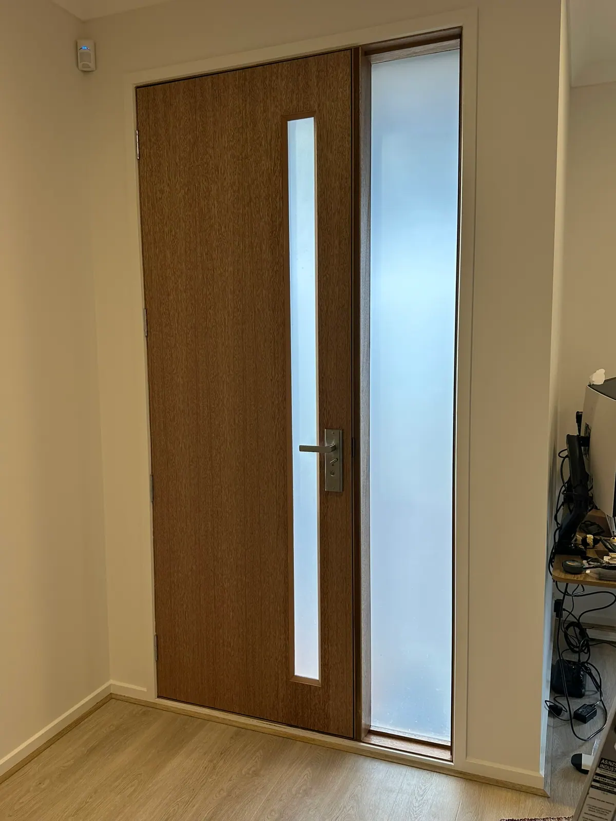 We applied frosted privacy window film to the glass panels of this newly built home's front entrance, creating a clean, contemporary finish that complements the natural timber door.