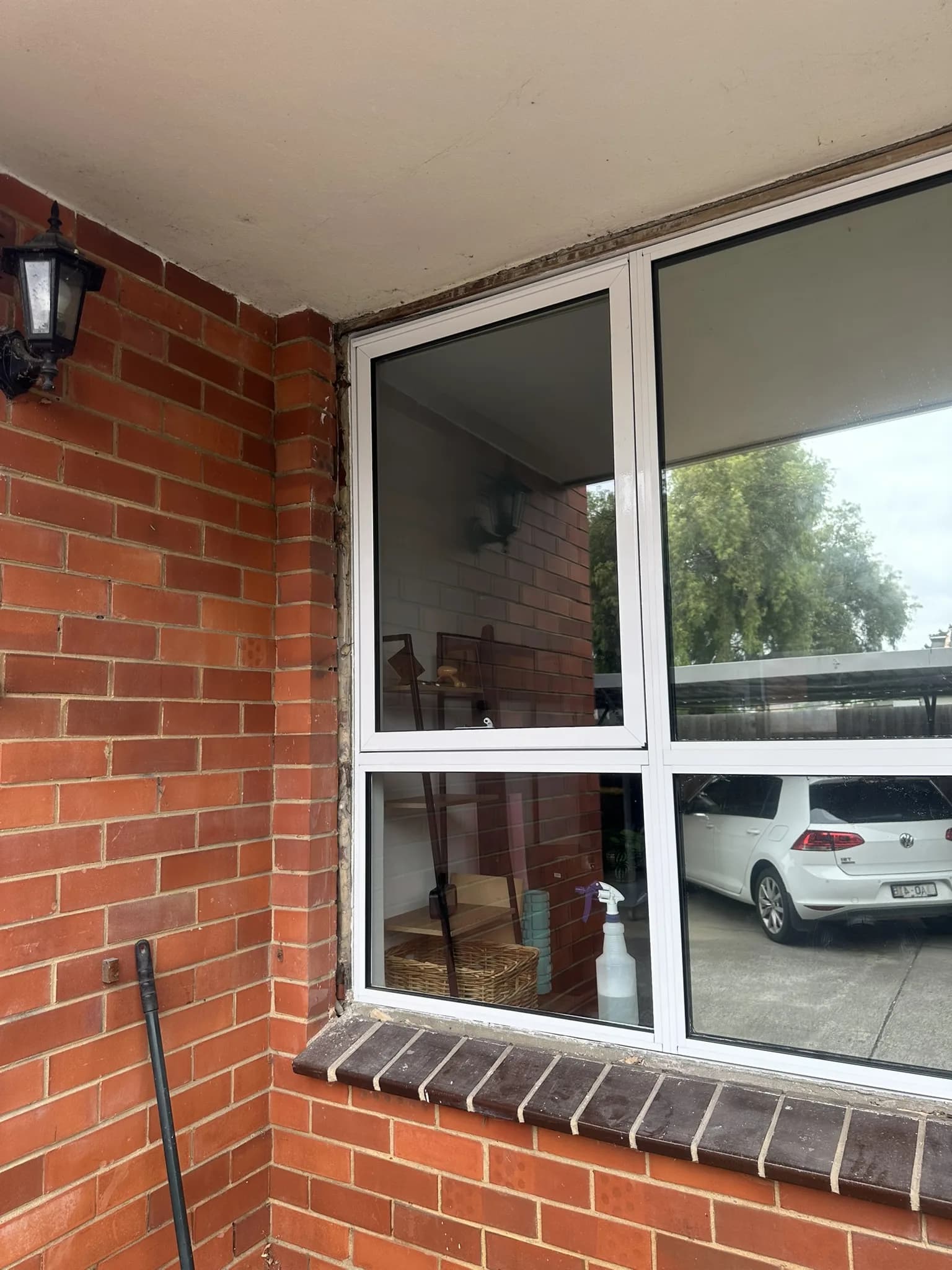 Dark mirror tint installed on driveway-facing apartment windows to provide strong daytime privacy, reduce visibility from shared areas and help reflect heat.