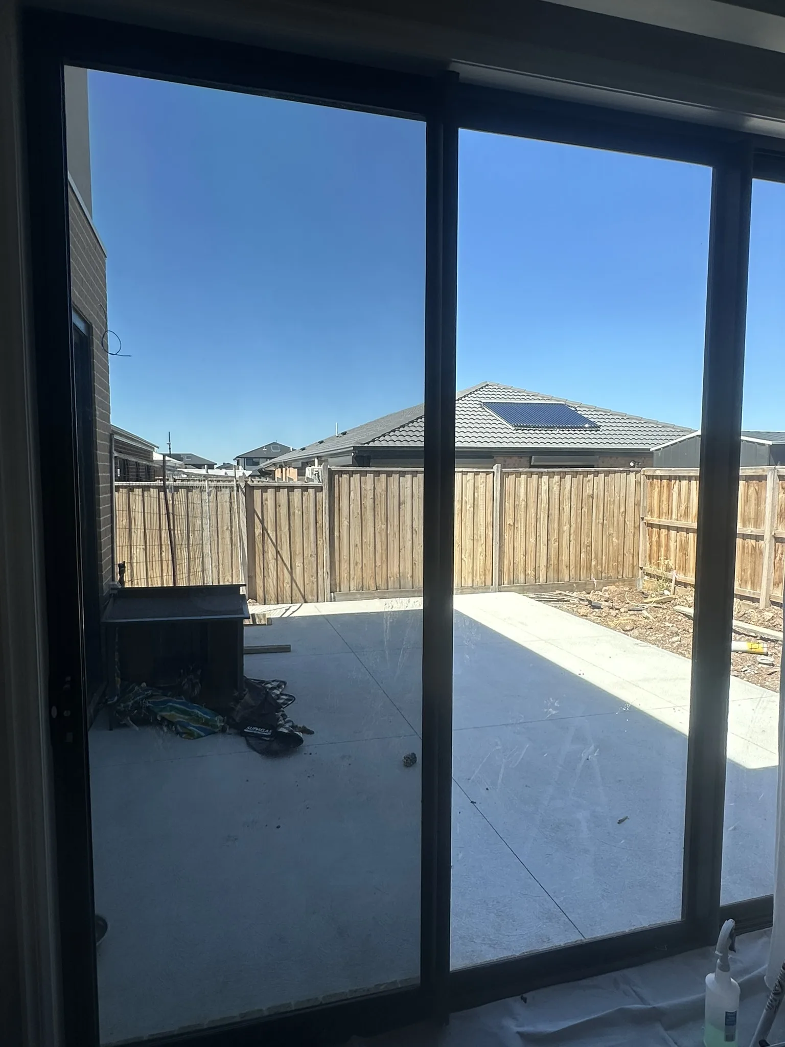 30 per cent tint on the large sliding doors and kitchen windows of a Fraser Rise new build. The estate has no established canopy and these doors face open sky, so the room was taking direct afternoon sun with nothing in front of it. The film cuts the glare and heat at the glass while keeping the view into the yard.